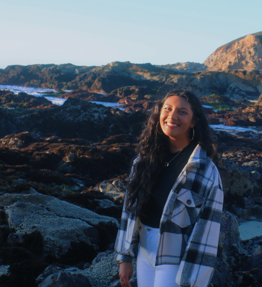 Student standing near rocky tidepools